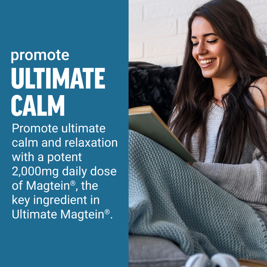 Woman smiling while reading a book under a cozy blanket