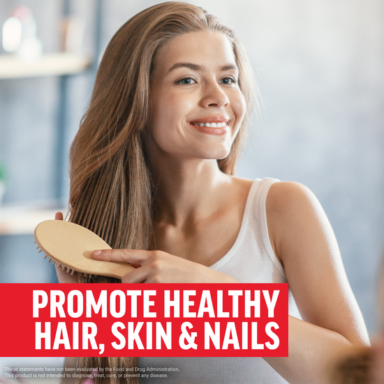 Woman smiling while brushing her hair, promoting healthy hair, skin, and nails