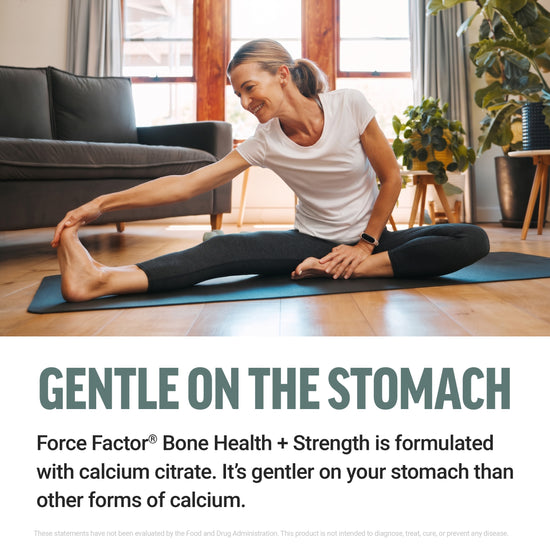 Woman stretching on a yoga mat at home, promoting calcium citrate formula that's gentle on the stomach