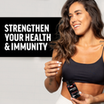 Woman in a black top smiling while holding a supplement bottle, with text promoting health and immunity.