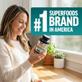 Woman smiling while holding Modern Mushrooms Gummies bottle, Force Factor #1 Superfoods Brand in America