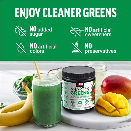 Green smoothie next to a jar of Smarter Greens supplement and fresh fruits on a white counter, highlighting clean ingredients.