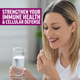 Woman smiling while holding a supplement capsule and glass of water