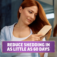 Woman brushing red hair with text showing reduced shedding in as little as 60 days