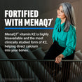 Woman in teal blouse leaning on a railing, promoting fortification with bioavailable MenaQ7 vitamin K2
