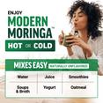 Woman drinking a green smoothie with 'Modern Moringa' branding and usage instructions.