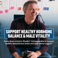 Man smiling in office holding a camera, promoting healthy hormone balance and male vitality with Shoden Ashwagandha
