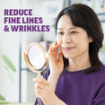 Woman holding a mirror while touching her cheek, promoting fine line and wrinkle reduction